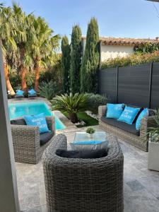 a patio with wicker furniture and a swimming pool at Superbe villa golfe st Tropez in Sainte-Maxime