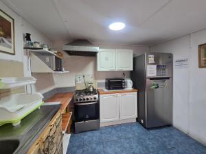 a small kitchen with a stove and a refrigerator at Andes Hostal Serena in La Serena