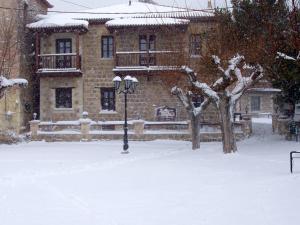 a street light in front of a building in the snow at Ξενώνας Αρχοντικό Πρεδάρη in Goura