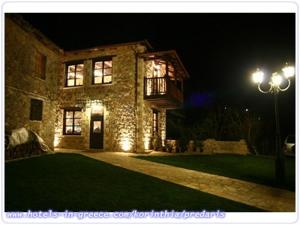 a large stone house with a balcony at night at Ξενώνας Αρχοντικό Πρεδάρη in Goura