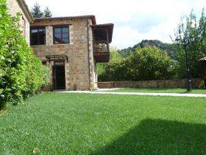 a house with a green lawn in front of it at Ξενώνας Αρχοντικό Πρεδάρη in Goura