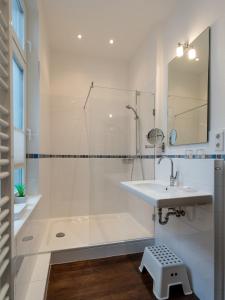 a white bathroom with a sink and a shower at Hotel Gutenberg in Westerland