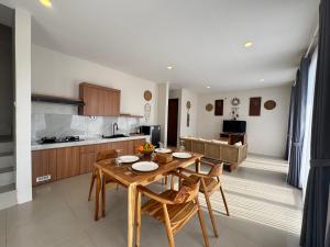 a kitchen and dining room with a wooden table and chairs at Jungle Valley Villas in Susut