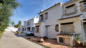 a white house with a car parked in the driveway at Rosalalinda - cosy semi-detached home with sea views and large terrace in Moraira