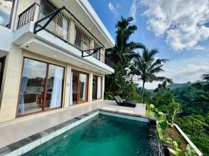 a villa with a swimming pool in front of a house at Jungle Valley Villas in Susut