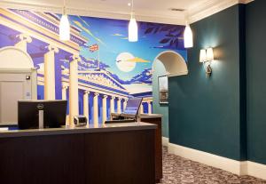 a hotel lobby with a mural of a church at Thistle London Bloomsbury Park in London