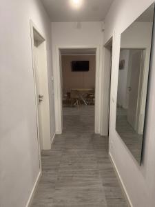 a hallway with a mirror and a room with a table at Lingen Stay in Lingen +7 photos
