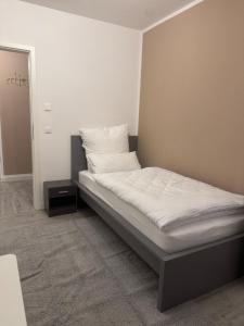 a bed with white sheets and pillows in a room at Lingen Stay in Lingen