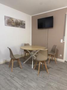 a dining room with a table and chairs and a television at Lingen Stay in Lingen