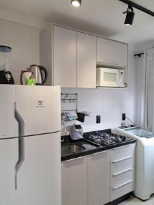 a kitchen with white cabinets and a white refrigerator at Apartamento completo e perfeito, Ao lado da Weg in Jaraguá do Sul +17 photos