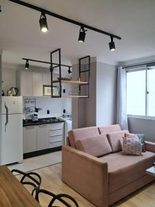a living room with a couch and a kitchen at Apartamento completo e perfeito, Ao lado da Weg in Jaraguá do Sul