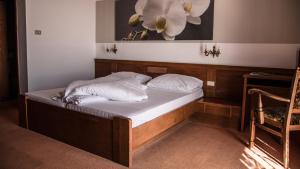 a bed in a room with a flower painting on the wall at Hotel Traubenwirt in Marlengo