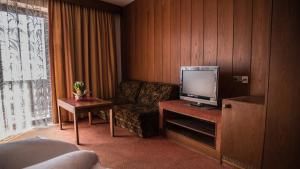 a living room with a couch and a tv at Hotel Traubenwirt in Marlengo +14 photos