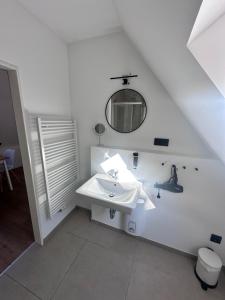 a white bathroom with a sink and a mirror at Appartementhaus Obertrave in Lübeck +37 photos