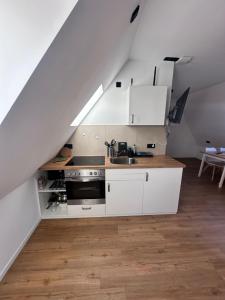 a kitchen with white cabinets and a sink at Appartementhaus Obertrave in Lübeck