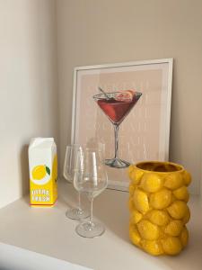 a table with two glasses and a picture and a vase at Appartement Saint-Louis in Verdun-sur-Meuse +21 photos