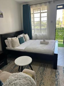 a bedroom with a bed with a table and a window at JOJO Staycations in Rungiri