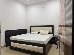 a small bedroom with a bed with white sheets at HOTEL INDRANEEL Hanuman Garhi in Ayodhya