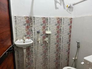 a bathroom with a shower curtain and a sink at HOTEL INDRANEEL Hanuman Garhi in Ayodhya