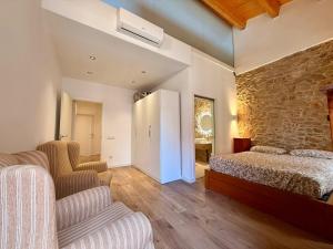 a bedroom with a bed and a stone wall at CASA EN EL CENTRO DE CALELLA A 300 m DE LA PLAYA in Calella