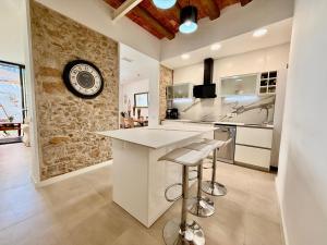 a kitchen with a counter and a clock on a wall at CASA EN EL CENTRO DE CALELLA A 300 m DE LA PLAYA in Calella