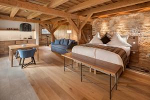 um quarto com uma cama, um sofá e uma mesa em AlmRefugio em Neumarkt in der Oberpfalz