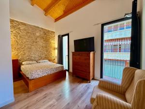 a bedroom with a bed and a tv and a couch at CASA EN EL CENTRO DE CALELLA A 300 m DE LA PLAYA in Calella