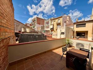 a balcony with a table and a bench on a building at CASA EN EL CENTRO DE CALELLA A 300 m DE LA PLAYA in Calella