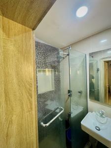 a bathroom with a glass shower and a sink at Abuja Circa Suite in Abuja