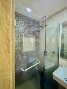 a bathroom with a glass shower and a sink at Abuja Circa Suite in Abuja