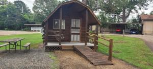 a small cabin with a bench and a table at Texarkana KOA Journey in Texarkana