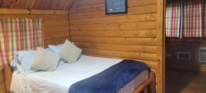 a bed in a wooden room in a cabin at Texarkana KOA Journey in Texarkana +5 photos