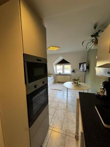 a kitchen with a refrigerator and a table at 1-Zimmer Apartment Waldperle in Erftstadt