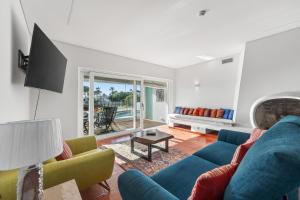 a living room with a blue couch and a tv at Casa Mimosa by Algarve Holidays in Vale do Lobo