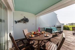 a patio with a wooden table and chairs at Casa Mimosa by Algarve Holidays in Vale do Lobo