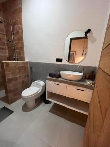 a bathroom with a toilet and a sink and a mirror at Villa Semoga in Tanjung +21 photos
