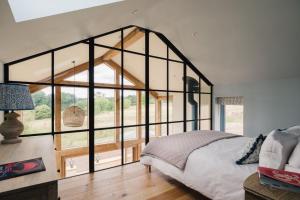 a bedroom with a large glass wall at The Tractor Shed in Combrook