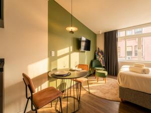 a hotel room with a bed and a table and chairs at Xtay Cais Rooftop -Estúdios completos e Rooftop para o Rio Guaíba in Porto Alegre