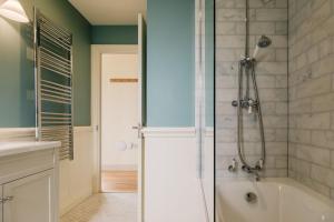 a bathroom with a shower and a bath tub at The Tractor Shed in Combrook +20 photos