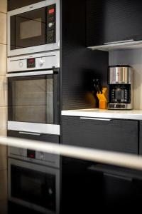 a kitchen with two ovens and a microwave at Villa Länsihuippu Incl WiFi, Pool table, AC, Jacuzzi for extra fee in Himos +28 photos