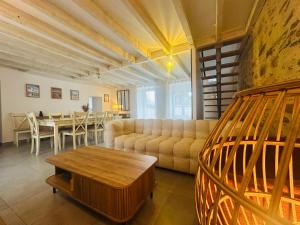 a living room with a couch and a table at Villa Bella & Spa in Mouilleron-le-Captif