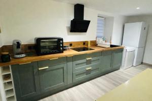 a kitchen with a counter with a microwave and a refrigerator at Villa Bella & Spa in Mouilleron-le-Captif +8 photos