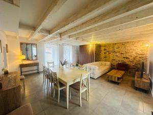 a living room with a table and a couch at Villa Bella & Spa in Mouilleron-le-Captif