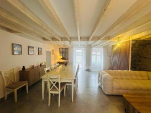 a living room with a table and a couch at Villa Bella & Spa in Mouilleron-le-Captif