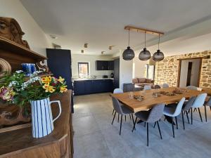 a kitchen and dining room with a wooden table and chairs at Gîte Le Granit des Champs in Mainsat