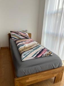 a bed with a pillow on it with a window at Very nice, Central and fully Furnished Apartment in Bonn