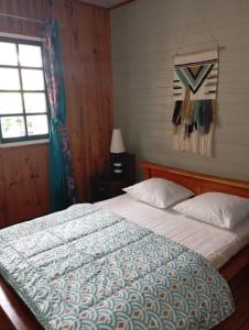 a bedroom with a large bed with a window at chez Margot in Le Tampon