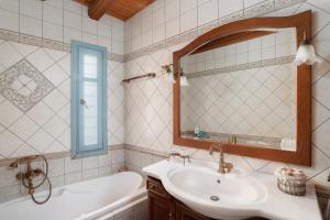 a bathroom with a sink and a tub and a mirror at villa eirini in Kourélion +32 photos