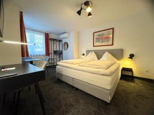 una camera d'albergo con un letto, una scrivania e un tavolo di Hotel Altmann a Vienna