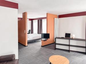 a hotel room with a bed and a television at THE GOOD ONE Hotel Landshut in Landshut